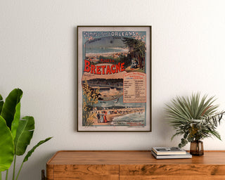 Vintage-Poster Bretagne – Strände der Bretagne, Eisenbahn, gerahmt über einer Holzkommode zwischen Pflanzen.