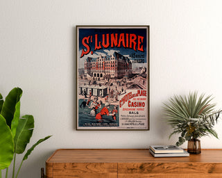 Vintage-Poster Bretagne – Saint-Lunaire, Seebäder, gerahmt über einer Holzkommode, zwischen Pflanzen.
