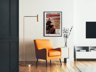 Vintage-Normandie-Poster – Cherbourg, Chemins de fer de l’Ouest, gerahmt in einem Wohnzimmer mit orangefarbenem Sessel und Stehlampe.