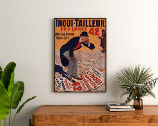 Werbeplakat Vintage Inoui-Tailleur, gerahmt über einer Holzkommode zwischen Pflanzen.