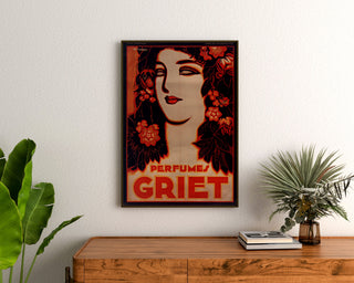 Vintage-Werbeplakat Perfumes Griet, gerahmt über einer Holzkommode zwischen Pflanzen.