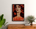 Vintage-Werbeplakat Perfumes Griet, gerahmt über einer Holzkommode zwischen Pflanzen.