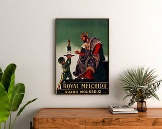 Vintage-Werbeplakat Royal Melchior, grand mousseux, gerahmt über einer Holzkommode zwischen Pflanzen.