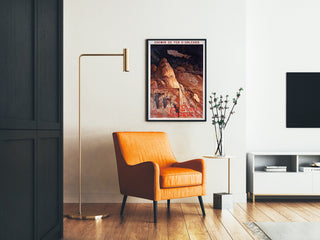 Vintage-Reiseplakat – Grottes de Lacave, Rocamadour, gerahmt im Wohnzimmer neben einem orangen Sessel und einer Stehlampe.
