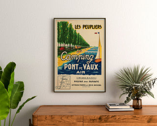 Vintage-Reiseplakat – Les Peupliers, Camping Pont-de-Vaux, gerahmt über einer Holzkommode zwischen Pflanzen.