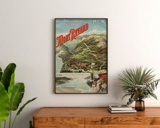 Vintage-Plakat «Aix-les-Bains, Mont-Revard, crémaillère», eingerahmt über einer Holzkommode, zwischen Pflanzen.