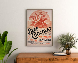Vintage-Plakat Beef Chocolat, Confiserie de la Drôme, gerahmt über einer Holzkommode, zwischen Pflanzen.