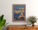 Vintage-Poster "Cannes, die eleganten Sportarten", gerahmt über einer Holzkommode, zwischen Pflanzen.
