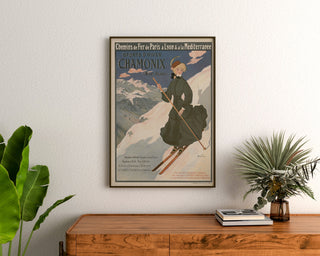 Vintage-Poster Chamonix, Wintersport PLM, gerahmt über einer Holzkommode zwischen Zimmerpflanzen.