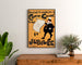 Vintage-Plakat Dudley Hardy, comic guide, gerahmt über einer Holzkommode, zwischen Pflanzen.