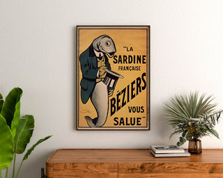 Vintage-Poster La Sardine française, Béziers, gerahmt über einer Holzkommode, zwischen Pflanzen.