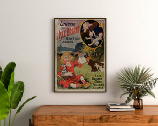 Vintage-Poster Laiterie de l’Isle Briant, Angers, gerahmt über einer Kommode aus Holz, zwischen Pflanzen.