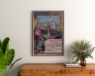 Vintage-Plakat Lourdes, Seebäder, gerahmt über einer Holzkommode zwischen Pflanzen.