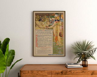 Vintage-Poster "Marseille, Jubiläumsfeiern", gerahmt über einer Holzkommode, zwischen Pflanzen.