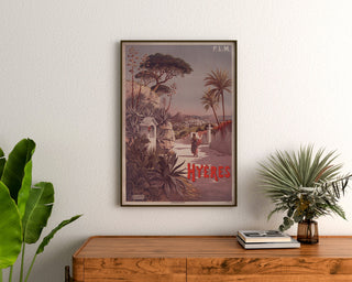 Vintage-Poster P. L. M. Hyères, gerahmt über einer Holzkommode zwischen Pflanzen.