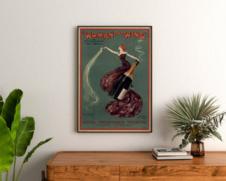 Vintage-Plakat Woman and Wine, Princess’s Theatre, gerahmt über einer Holzkommode, zwischen Pflanzen.